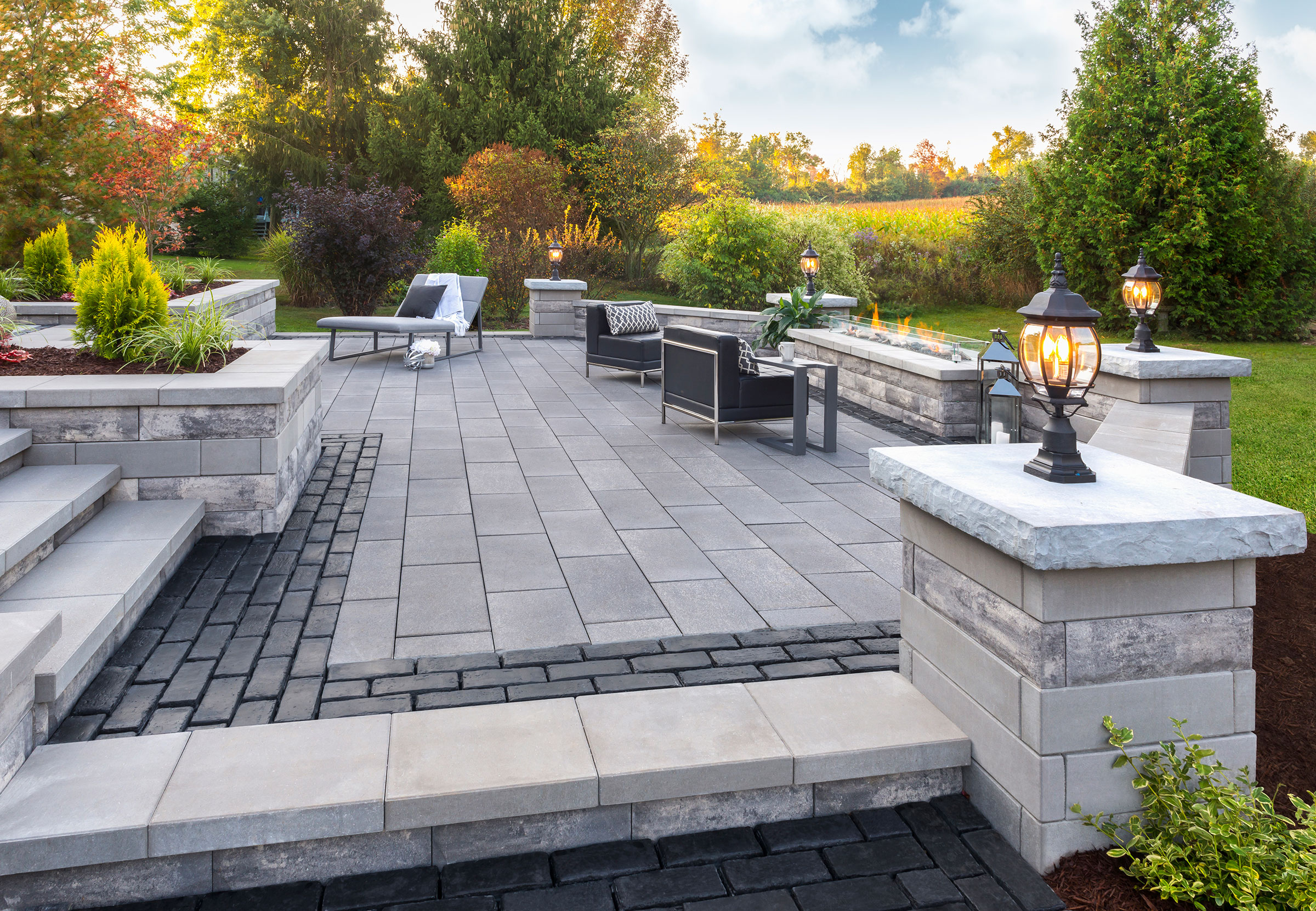 Elevated paver patio with pillar lighting at golden hour