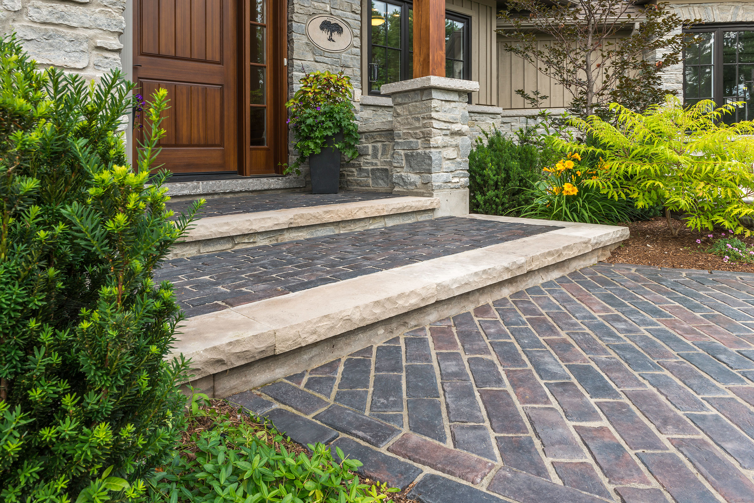 Front entry with stone steps and herringbone brick walkway